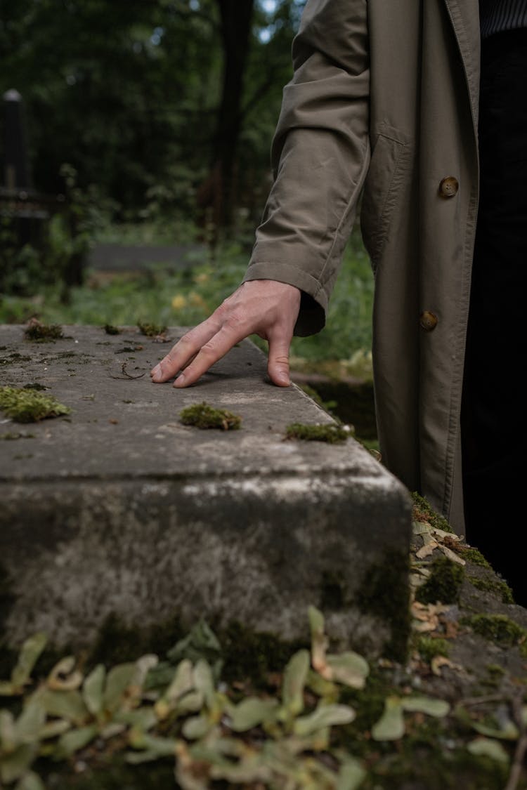 A Person Touching A Grave