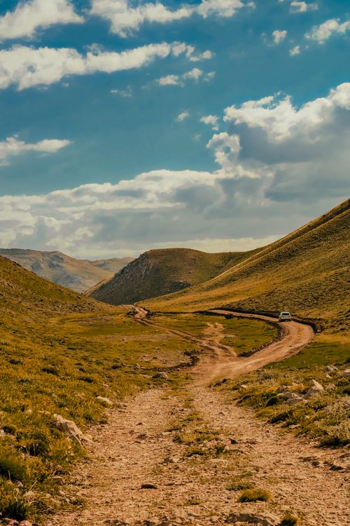 Free Explore the serene landscape of Turkey with rolling hills and an unpaved road under a bright sky. Stock Photo