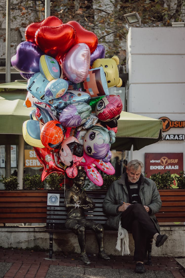 Assorted Balloons Tied On A Statue