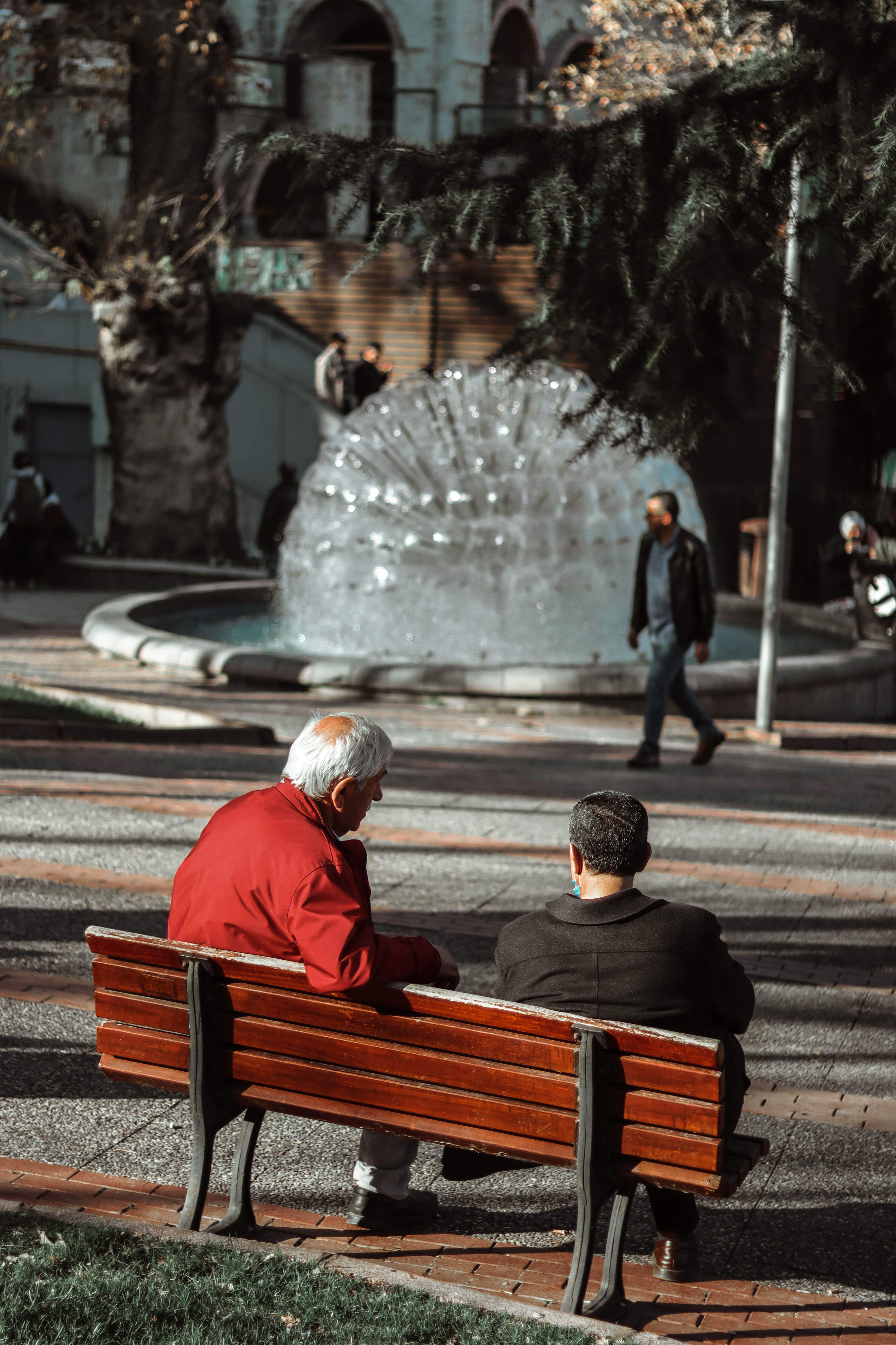 Two Old Men Sitting on Bench in Park in Autumn
