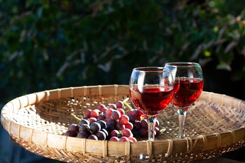 Glasses of Red Wine beside Grapes