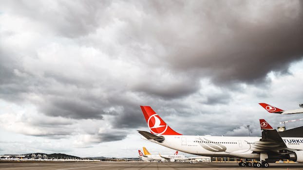 Turkish Airlines planes on the tarmac under overcast skies, showcasing aviation dynamics.