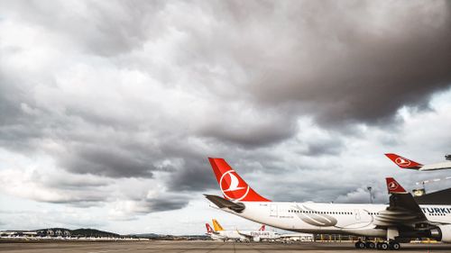 Free Turkish Airlines planes on the tarmac under overcast skies, showcasing aviation dynamics. Stock Photo