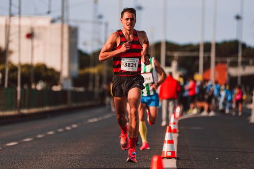 Free A focused man participating in a competitive road race with a blurred background. Stock Photo
