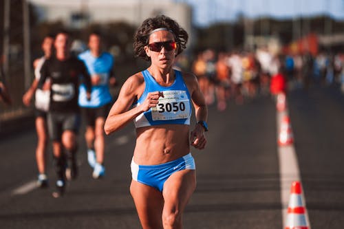 Woman in Sportswear and Shades Running