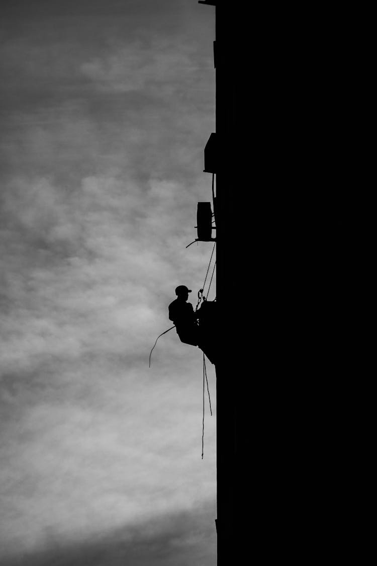 Silhouette Of Man Working At Height