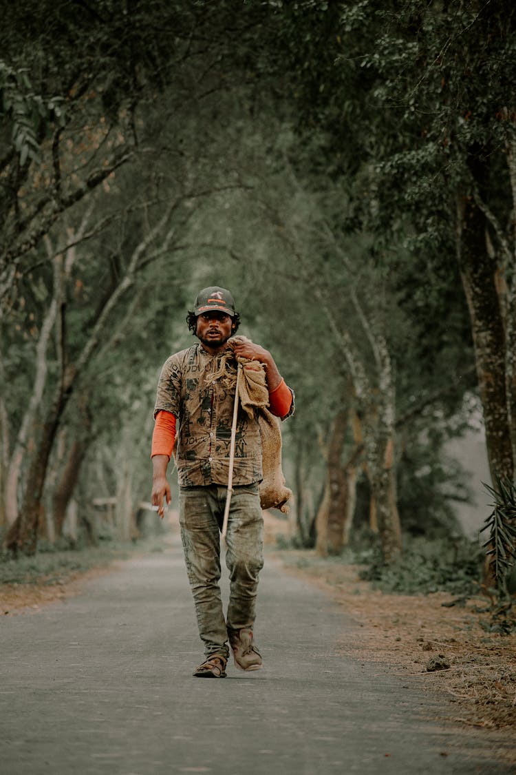 A Man Walking Carrying A Sack