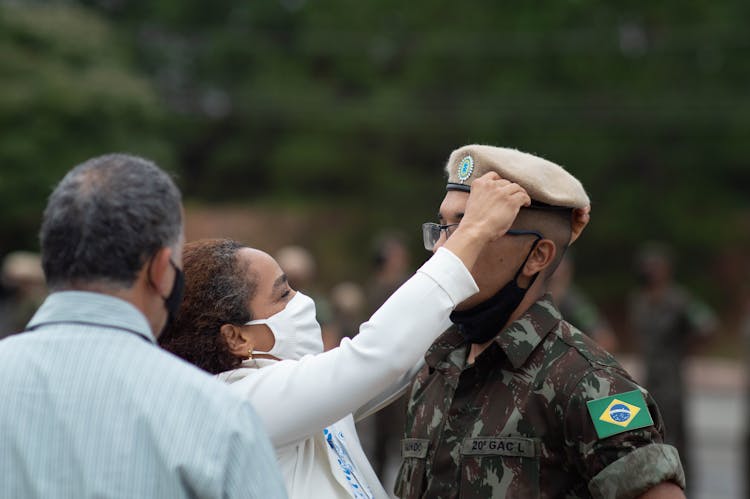 Woman Putting A Hat On A Military Men