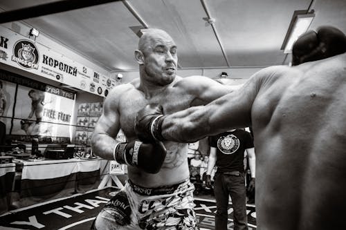 Grayscale Photo of a Man Punching His Opponent