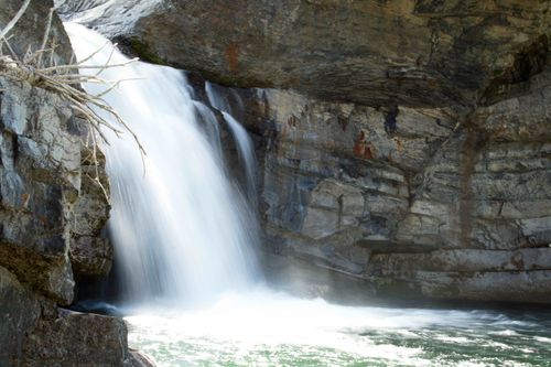 Free A beautiful waterfall cascades over rugged rocks, creating a serene natural landscape. Stock Photo