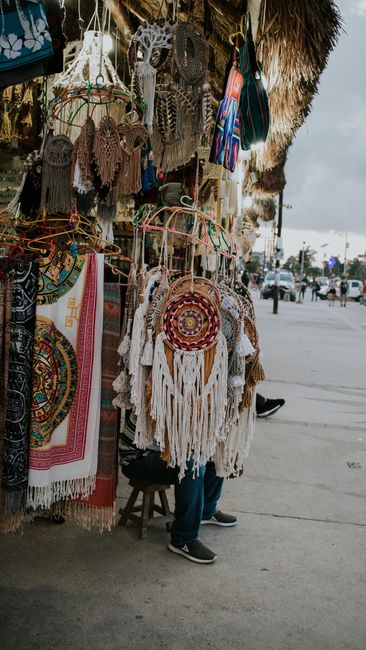 Colorful handwoven dreamcatchers and textiles hanging for sale at a Tulum street shop