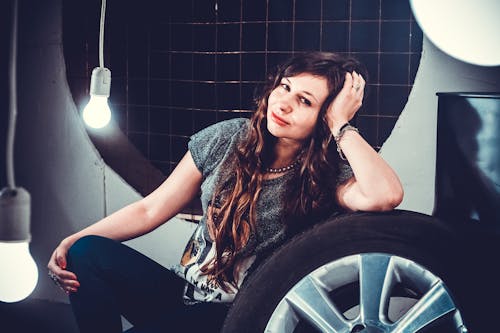 Woman in Gray Top Beside of Wheel With Tire