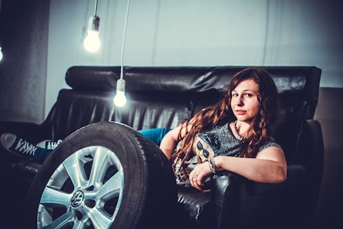 Free Woman Lying in Black Leather Couch Stock Photo