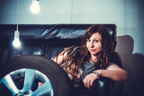 Free Photo of Woman Sitting on Couch Front of Wheel Stock Photo