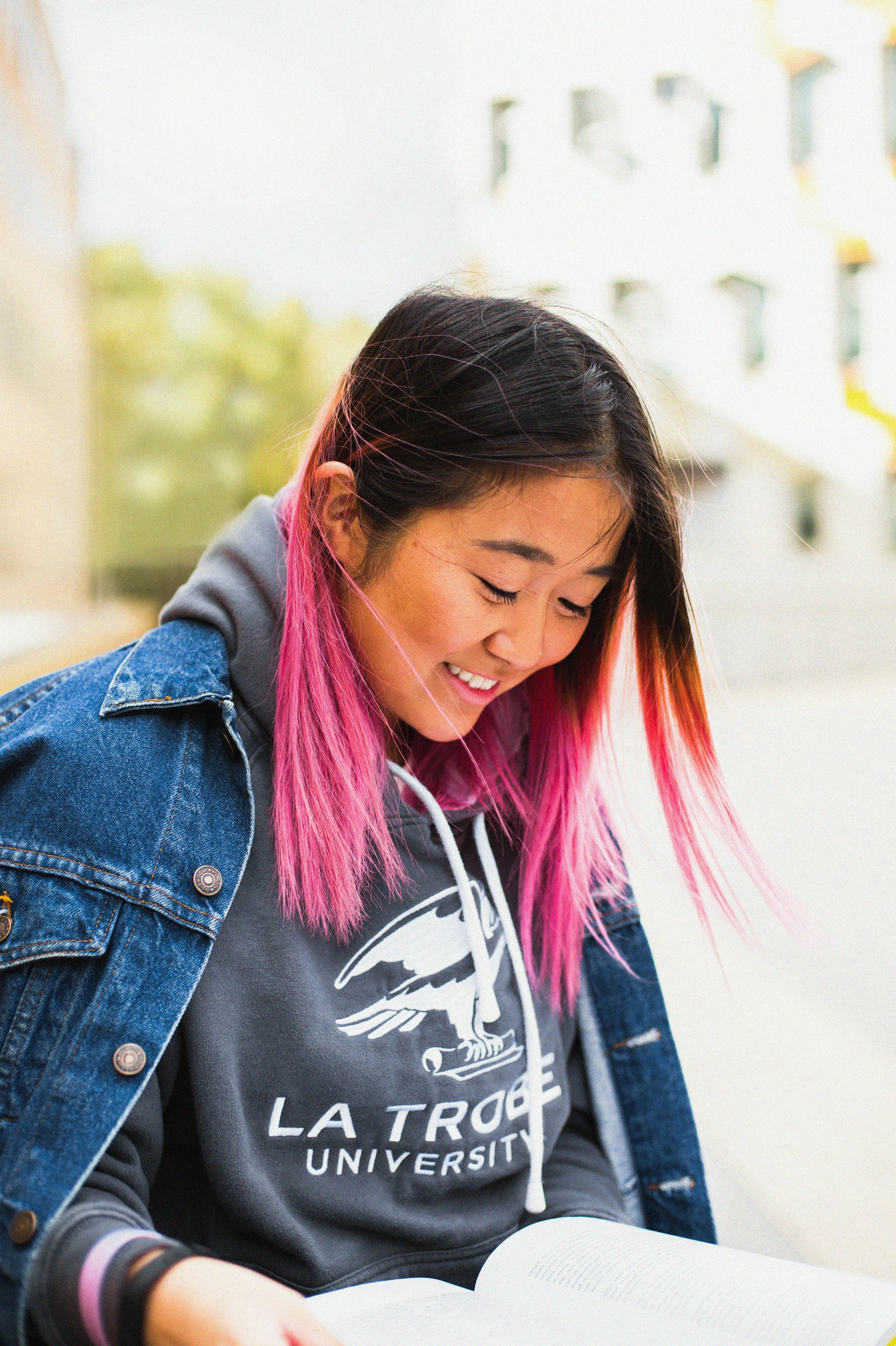 a woman wearing a denim jacket over a hoodie