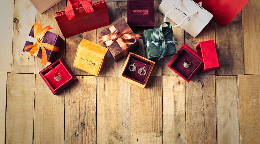 Bijoux élégants et sacs cadeaux disposés sur un parquet en bois pour la fête des mères