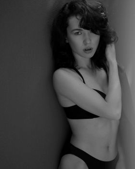 Stylish black and white portrait of a woman in lingerie, showcasing classic elegance.