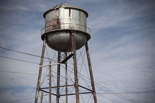 A rustic water tower with a cloudy sky backdrop in Rankin, TX, capturing industrial charm.