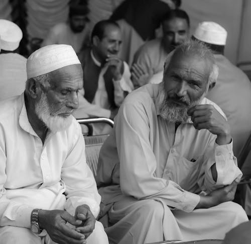 A Grayscale of Bearded Men Wearing Thobes