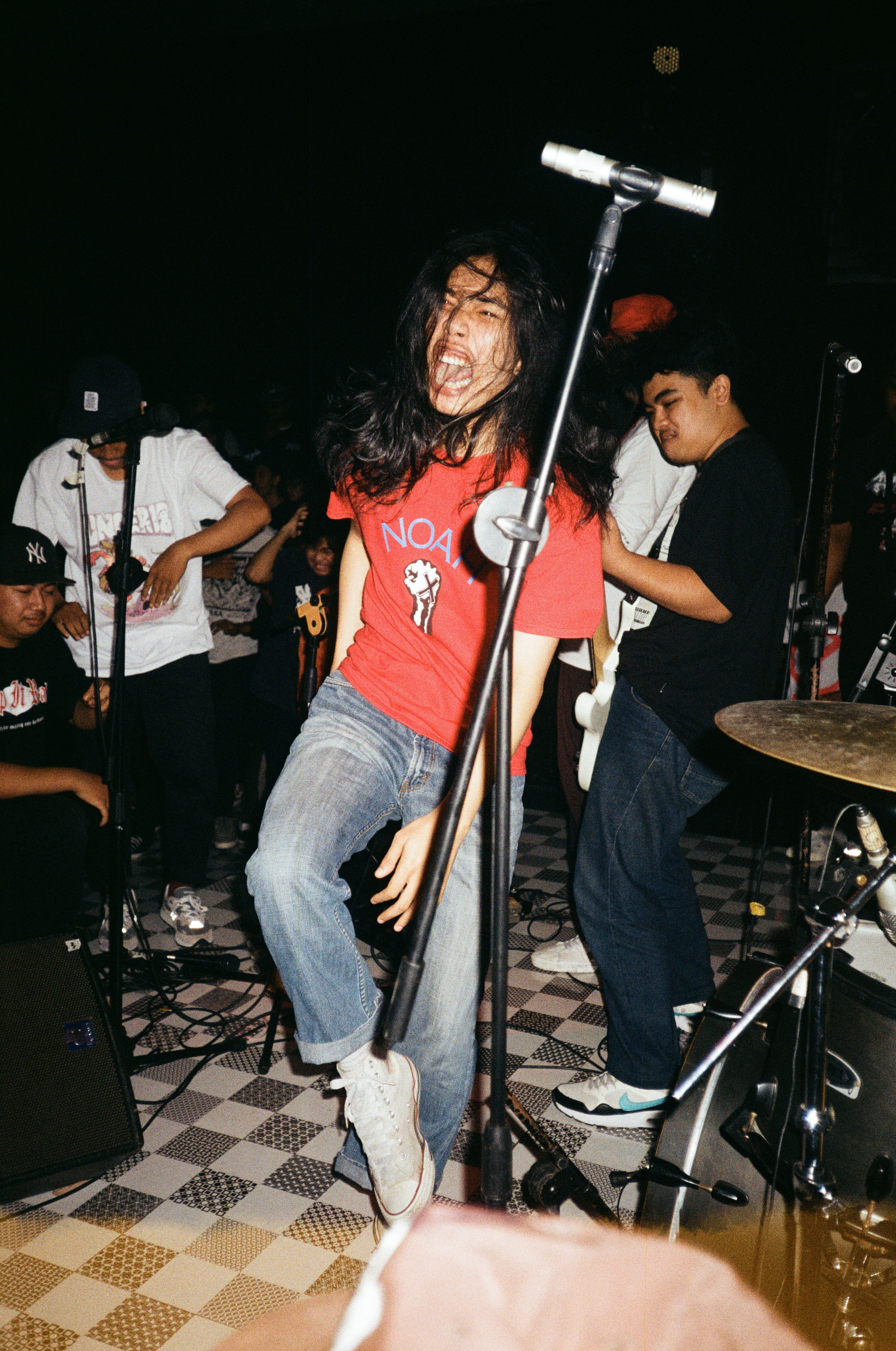 Man in Red Crew Neck T-shirt and Blue Denim Jeans Performing on Stage ...