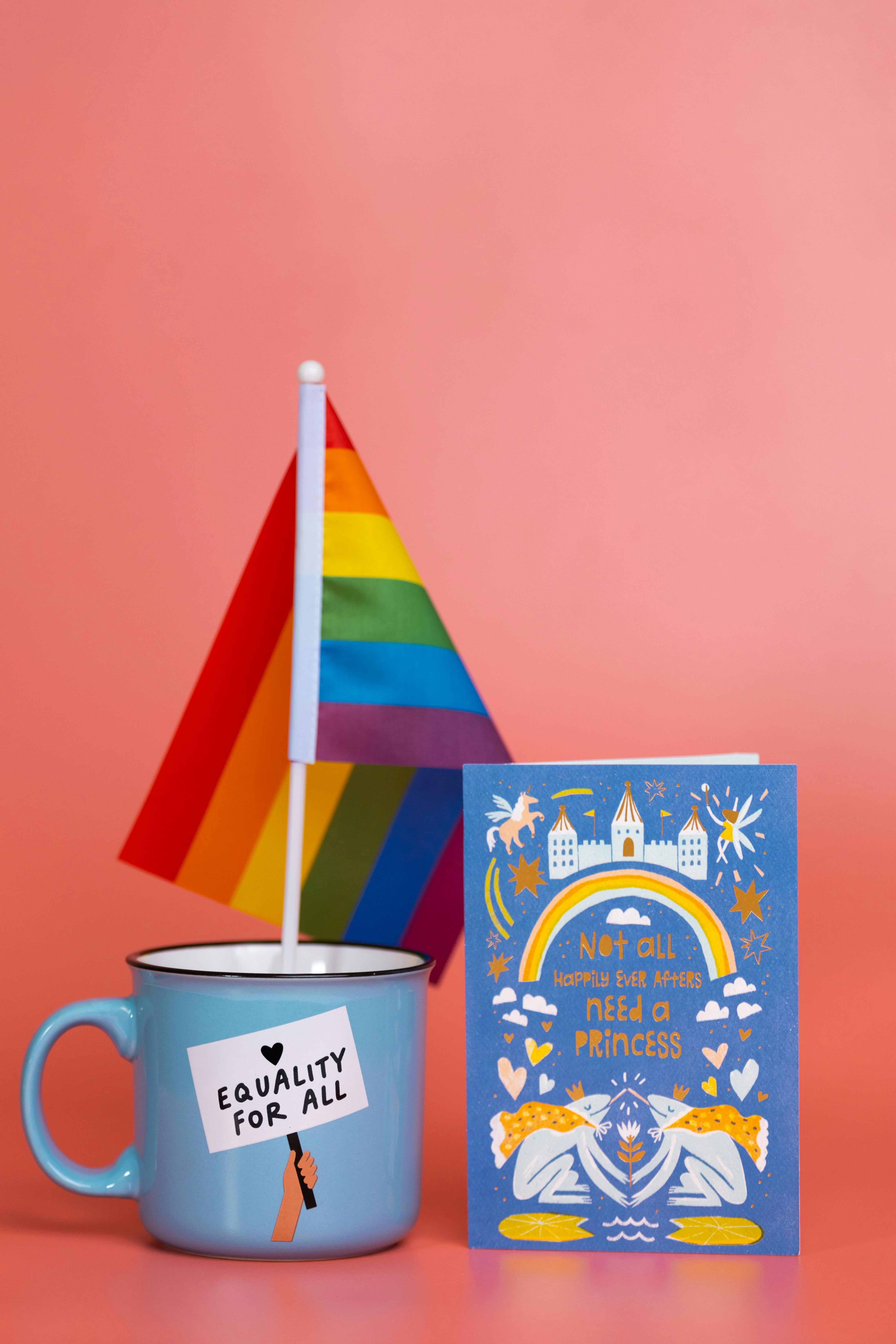 Colorful arrangement with equality mug and rainbow flag promoting inclusivity.