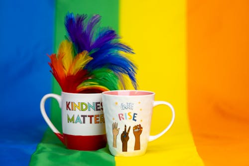 Free Mugs with Gay Pride Slogans against Rainbow Flag Stock Photo