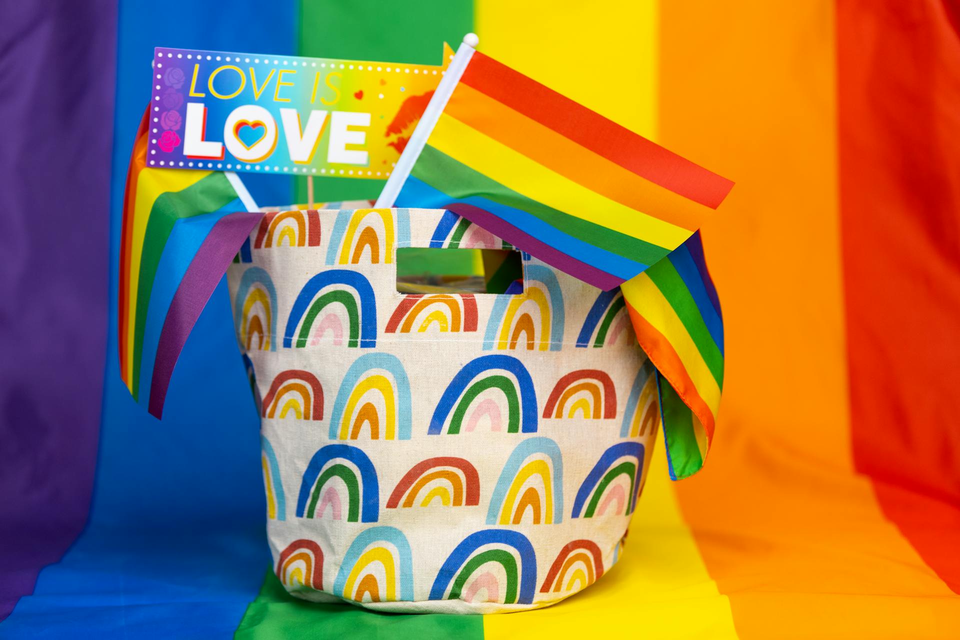 Colorful pride basket with rainbow flags and Love is Love sign, symbolizing LGBT pride.