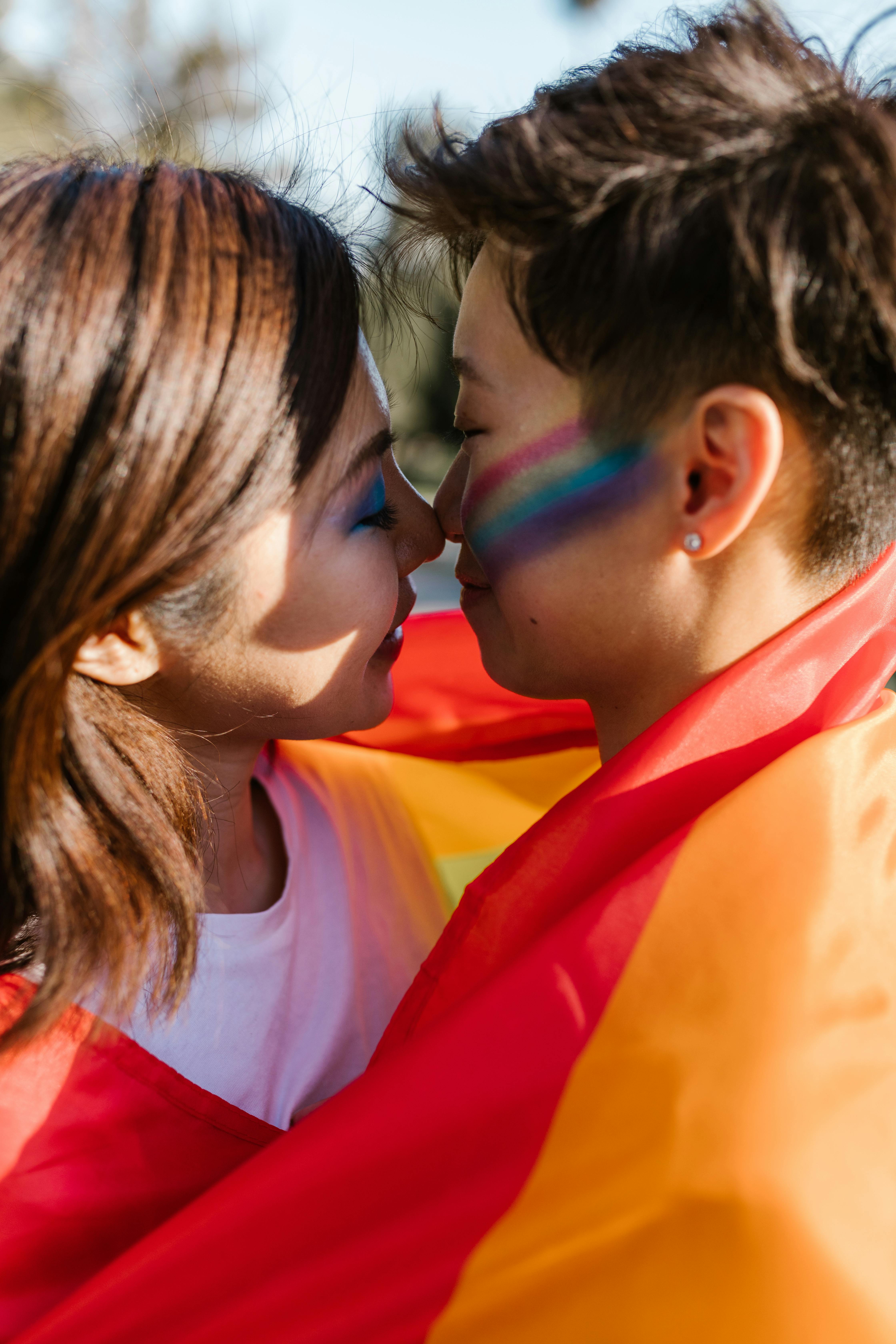 Lesbian Couple Wrapped in Pride Flag about to Kiss · Free Stock Photo