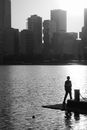 Silhouette of Man Standing on Boat on Water