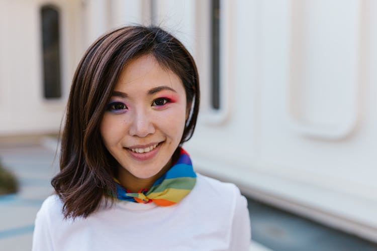 Portrait Of Woman In Makeup Wearing Rainbow Scarf Around Neck