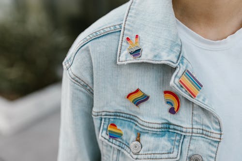 Person Wearing Rainbow Pins on their Jean Jacket