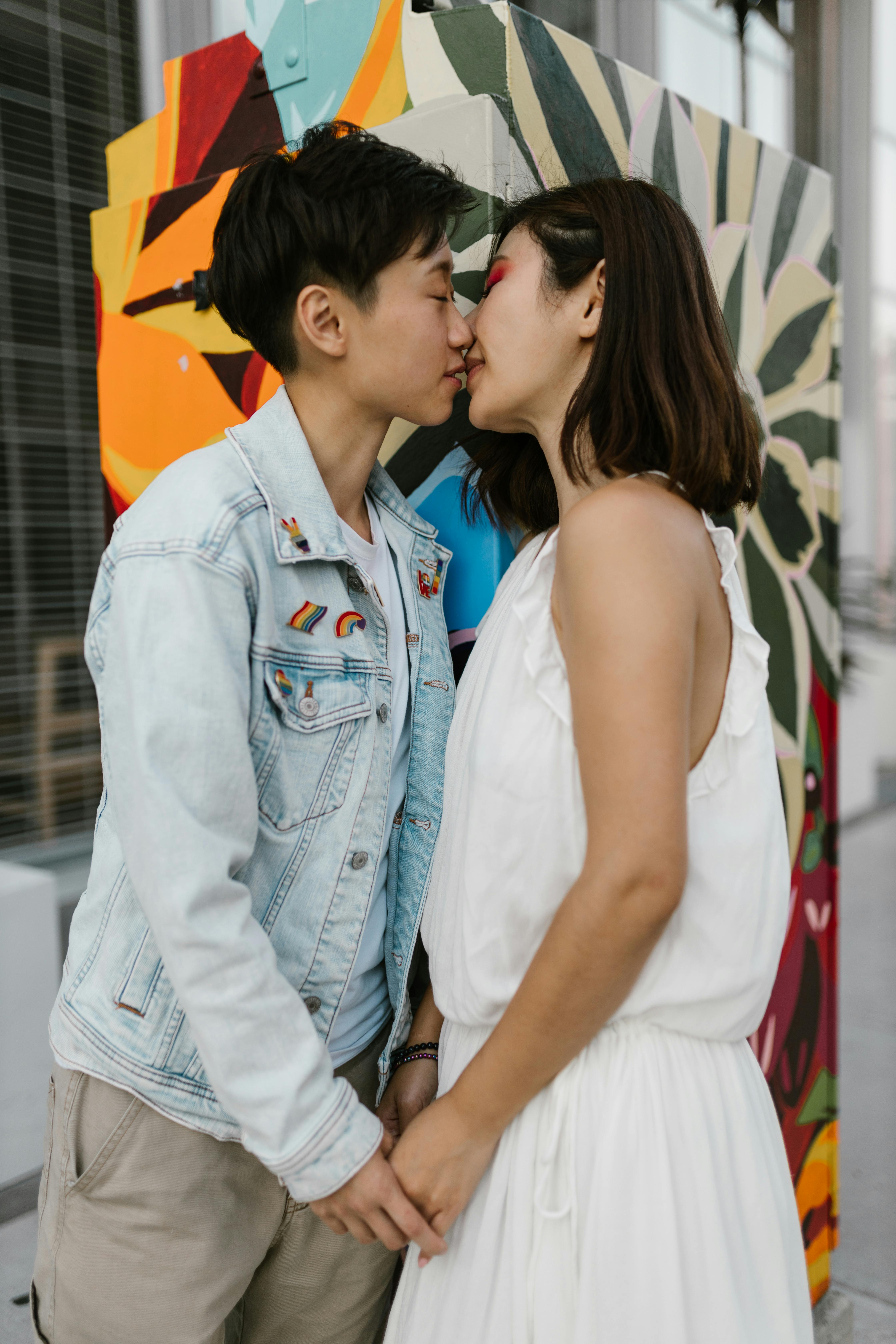 two women kissing while holding hands