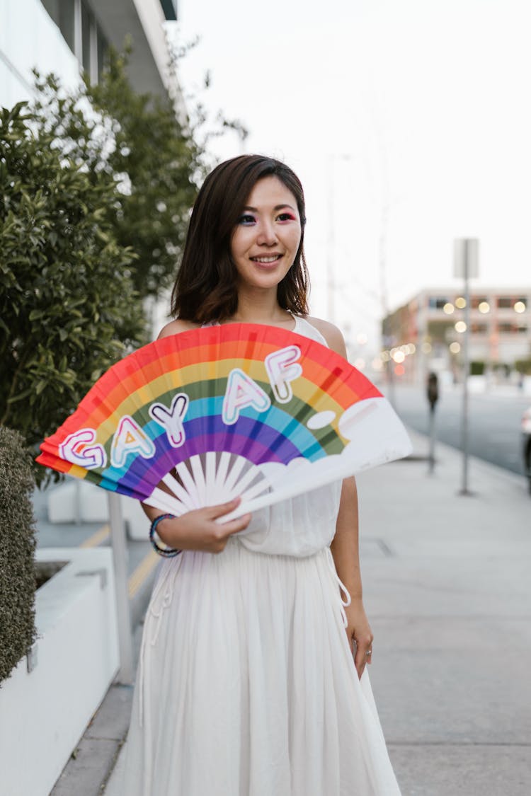 Smiling Woman Holding Pride Flag Handheld Fan