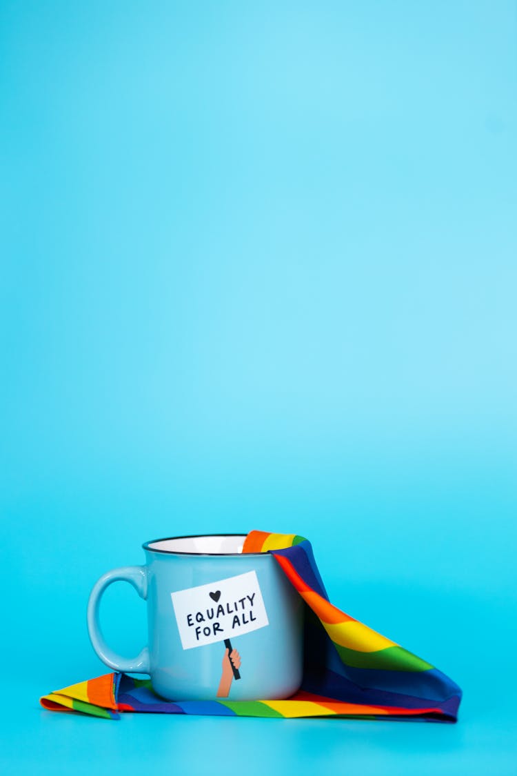 Blue Mug With Slogan Of Equity And Rainbow Cloth