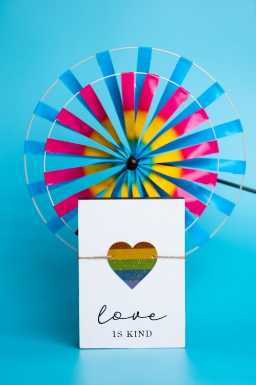 Free Vibrant pinwheel with a rainbow heart card expressing kindness on a blue background. Stock Photo