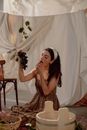 Woman Sitting in a Studio and Eating Grapes