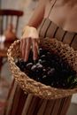 Woman Standing with a Braided Basket full of Grapes