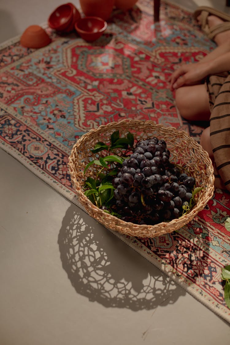 Basket Of Purple Grapes On Carpet