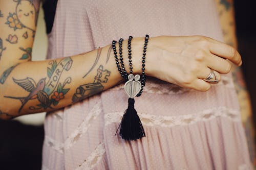 Close-Up Shot of an Arm of a Person with Tattoos and Accessories 