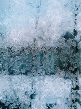 Beautiful frost patterns on a window, showcasing winter's intricate icy designs.