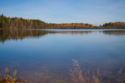 Free Tranquil lake reflecting autumn forest colors, capturing nature's beauty. Stock Photo