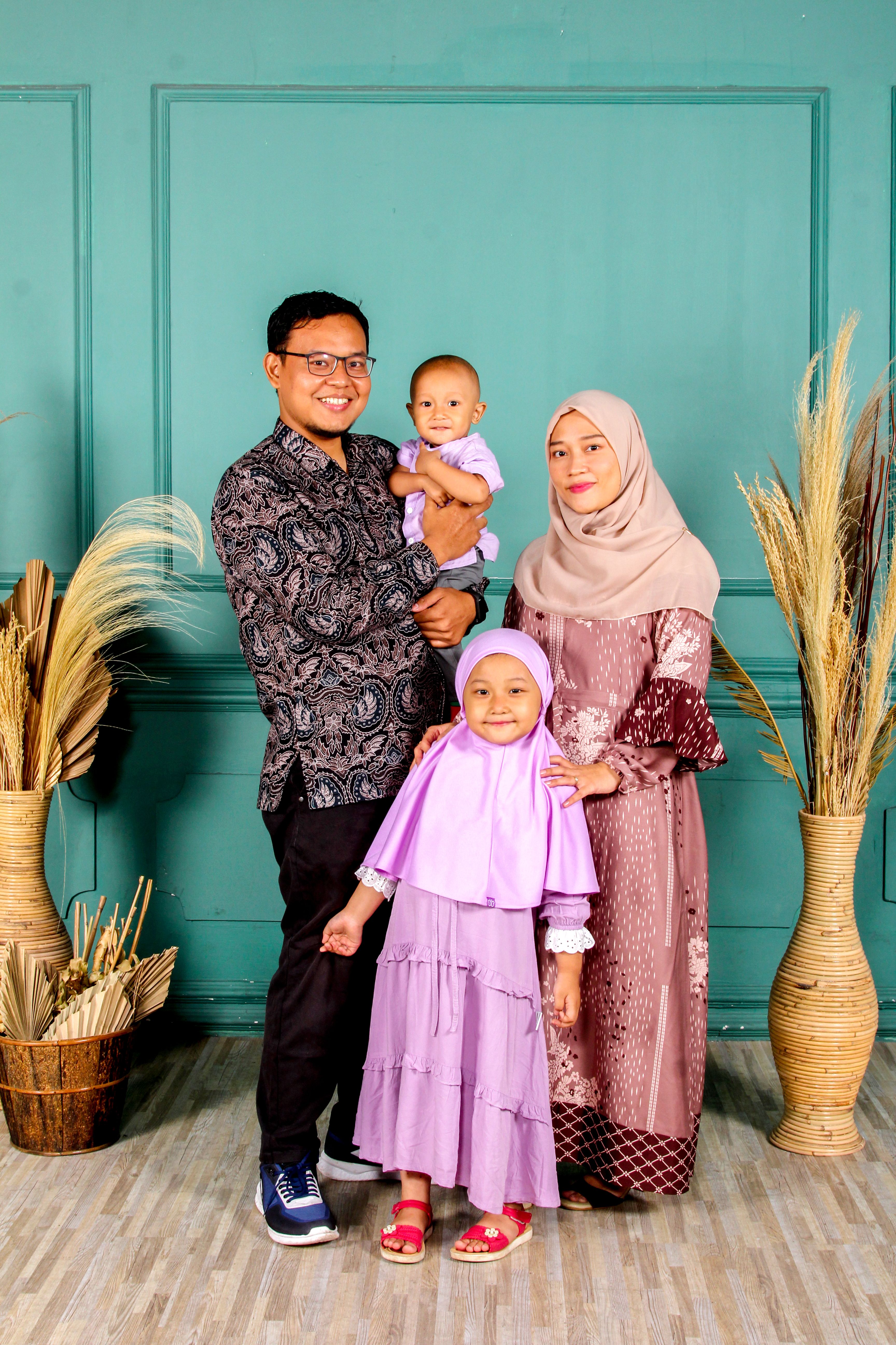 A joyful family portrait featuring parents and their smiling children in traditional attire, showcasing familial bonds.