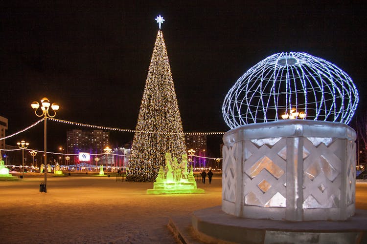 A Christmas Tree At Night In A City