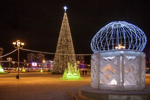 Free A beautifully lit Christmas tree in a festive urban setting, celebrating the winter season at night. Stock Photo