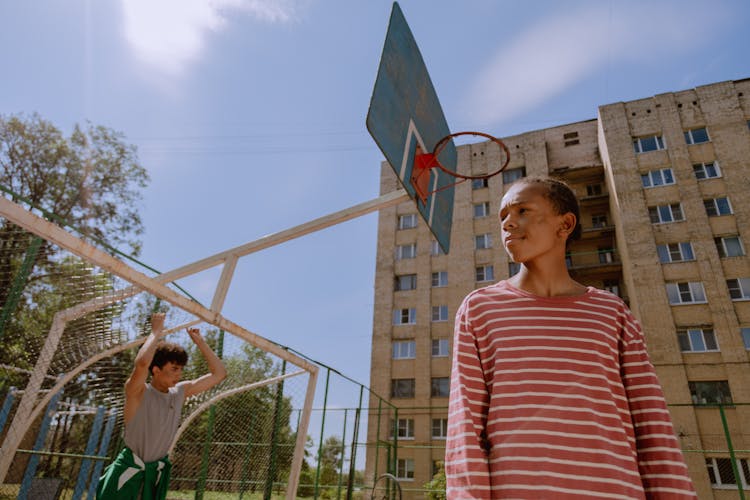 Low Angle Shot Of A Teenager In A Basketball Court 