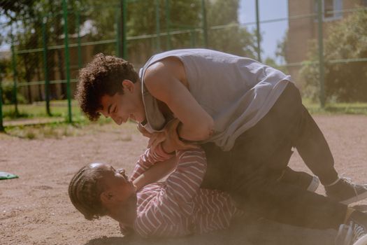 A Pair of Young Men  Playfully Brawling on the Ground