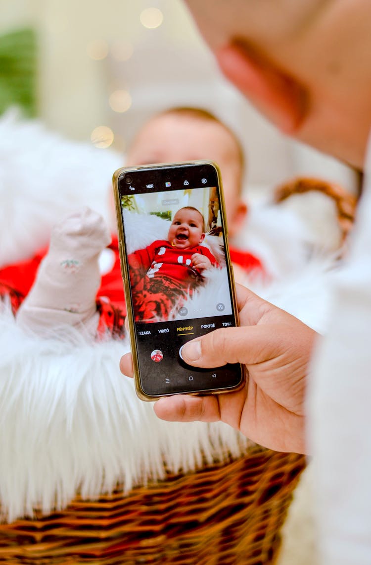 Person Taking Photo Of A Smiling Cute Baby