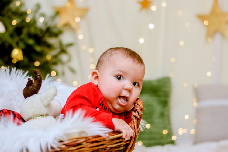 Baby In Red Shirt On Brown Woven Basket