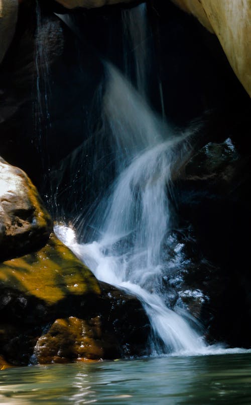 Photo of Running Water Between Brown Rocks