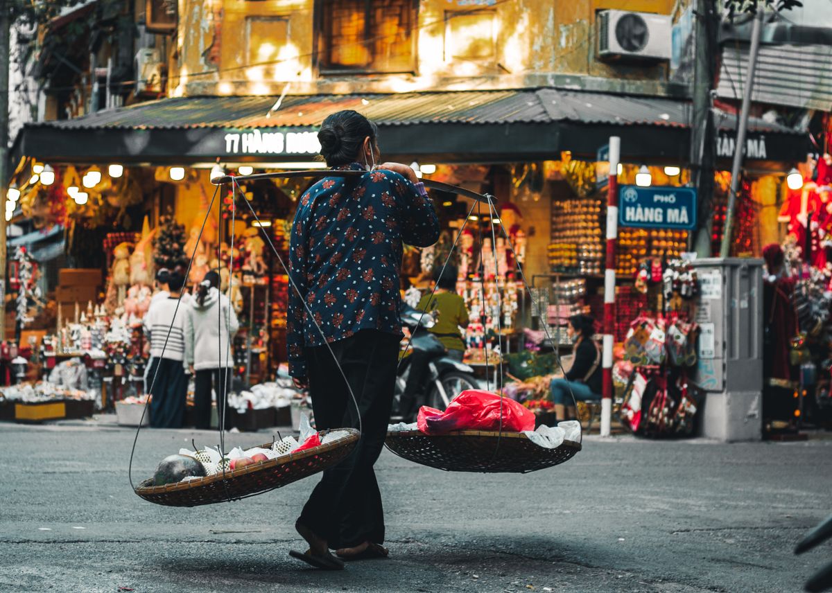 A Woman Carrying Winnowing Baskets with Fresh Fruits